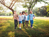 A group of diverse kids laughing and walking together in the park on a sunny day – celebrating childhood joy and friendship with Kidspeek.